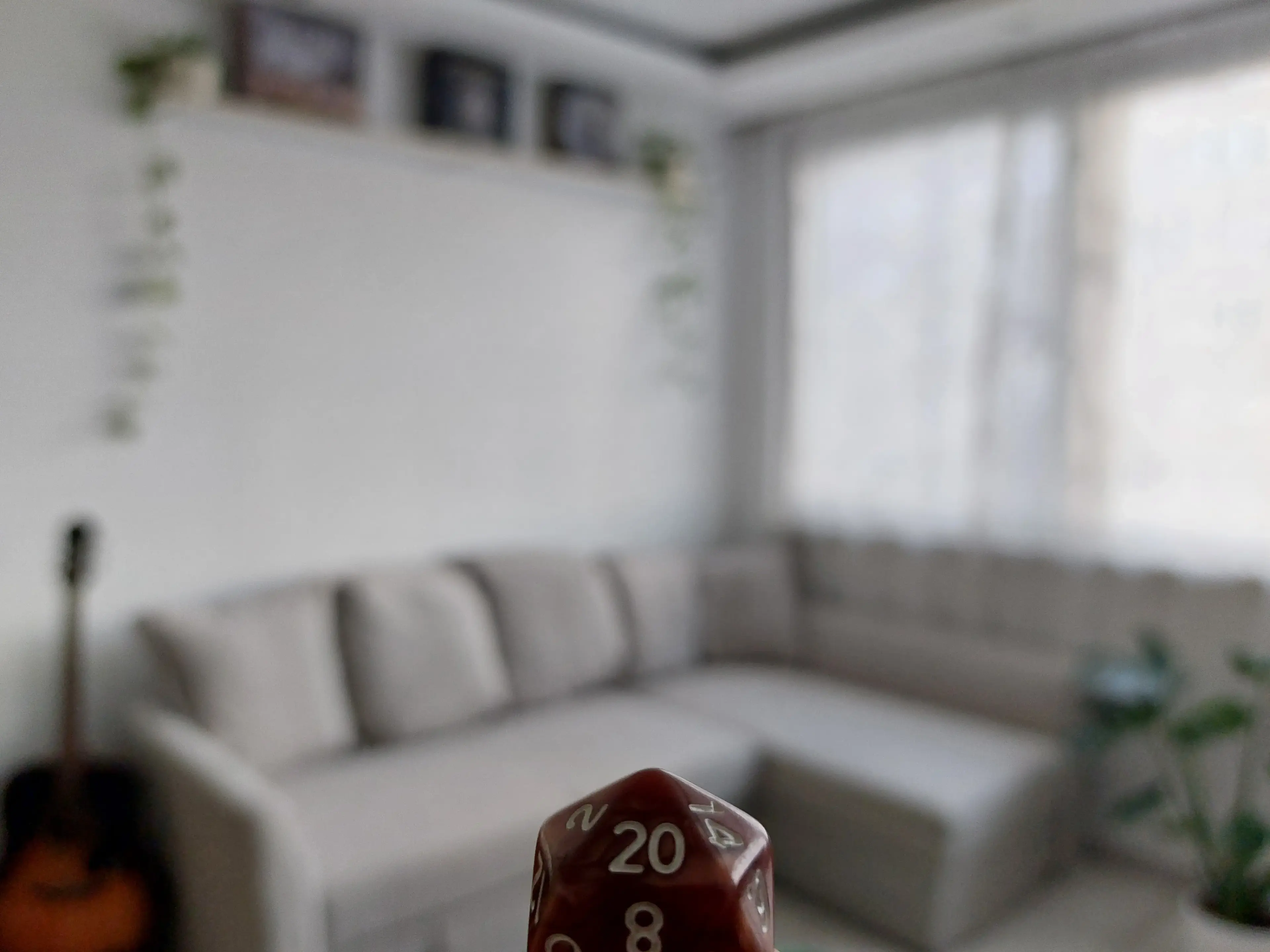 Egy 20 oldalú kocka fókuszban háttérben egy kanapéval